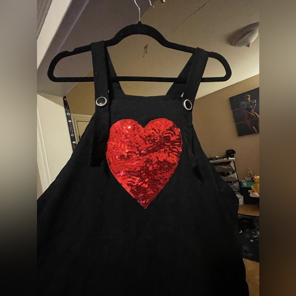 Black corduroy overall jumper dress with red sequin heart detail. - Picture 2 of 4